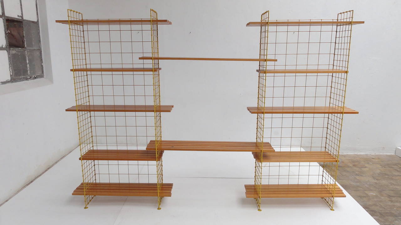 A true Dutch modernist masterpiece, this modular shelving unit consists of birch slats that can be placed in a yellow enameled metal wire frame.

The style is reminiscent to the works of Nisse Strinning (Sweden) and it was purchased at Metz & Co