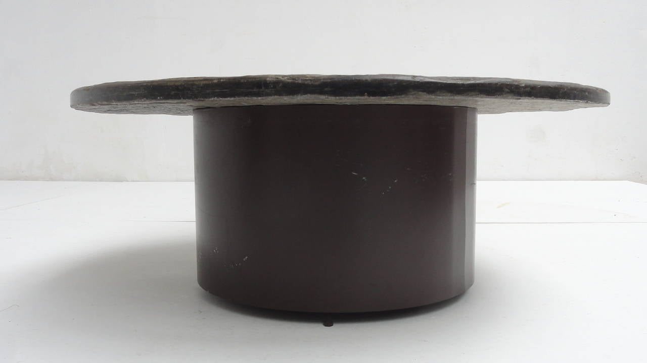 Beautiful round coffee table made out of 1 piece of round cut slate stone on a brown enameled metal base

The top has a lovely natural slate texture with a beautiful slate stone glaze

This 60's coffee table is in the style of Dutch artists Paul