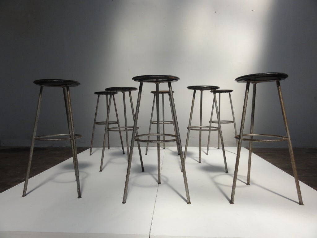 A unique set of 8 industrial barstools from Switzerland
3 legged with footrest and black lacquered wooden seatings (diameter 13.8 inch)