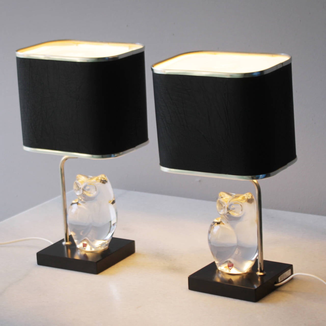 Set of rare table lamps with beautiful crystal owls by Olle Alberius for Orrefors Sweden. Period 1965-1975.
 
Black faux leather shades, but maybe it's real leather, I'm not sure can't see or feel the difference. Acrylic diffuser on top of the