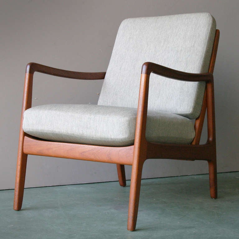 Chair by Ole Wanscher for France & Sons. FD 109 easy chair in teak. This chair is constructed out of solid teak and it has a luxurious orange hue with figures of dark grain throughout. The sculpted armrests are of special note. Their execution is