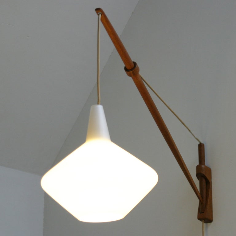 Beautiful rare wall light by Lisa Johansson-Pape, Finland. The lamp hangs delicately in balance and in an ingenious way adjustable with a wooden ring. Beautiful condition.
Measurements: Height: 17.7 in., Width: 9.8 in, Depth: 35.4 inches.
Please
