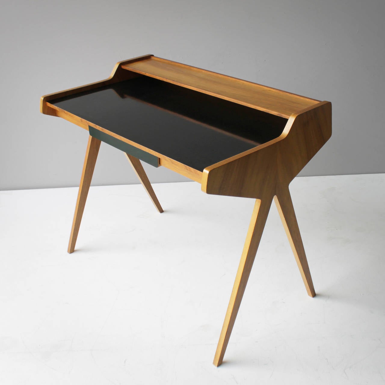 Rare ladies desk, designed by the German architect Helmut Magg. Beautiful organic formed writing desk in black formica veneer and walnut with one drawer. 
Good condition. Some minor scratches at the back and wear of age on the black top (see