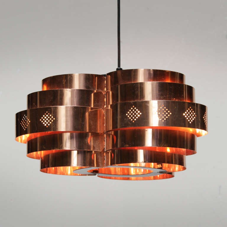 Copper pendant by Verner Schou for Coronell Elektro Denmark. In the style of Hans Age Jakobsson. Perforated red copper lamellae. 
Measurements height: 7.1 in. (18 cm), diameter: 14.6 in. (37 cm).