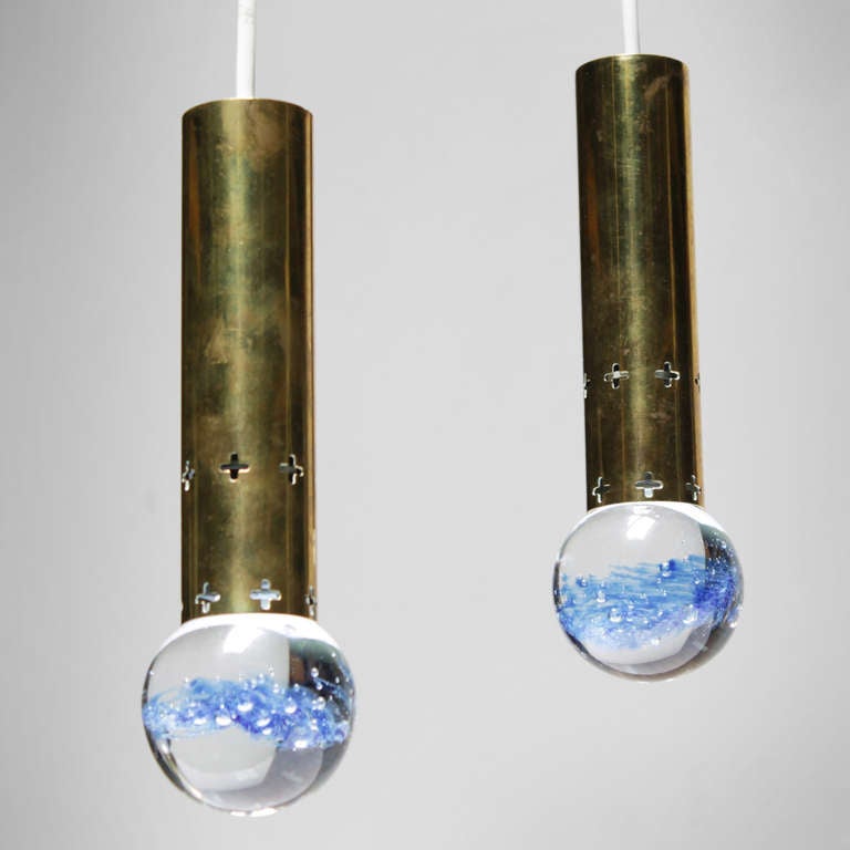 Pair of pendant lights from Scandinavia, probably Sweden. Solid bubble glass with blue traces, brass fixture. Design in the manner of Gino Sarfatti.
Measurements: height 9.2 in. (23,5 cm), diameter glass 2.7 inches (7 cm).