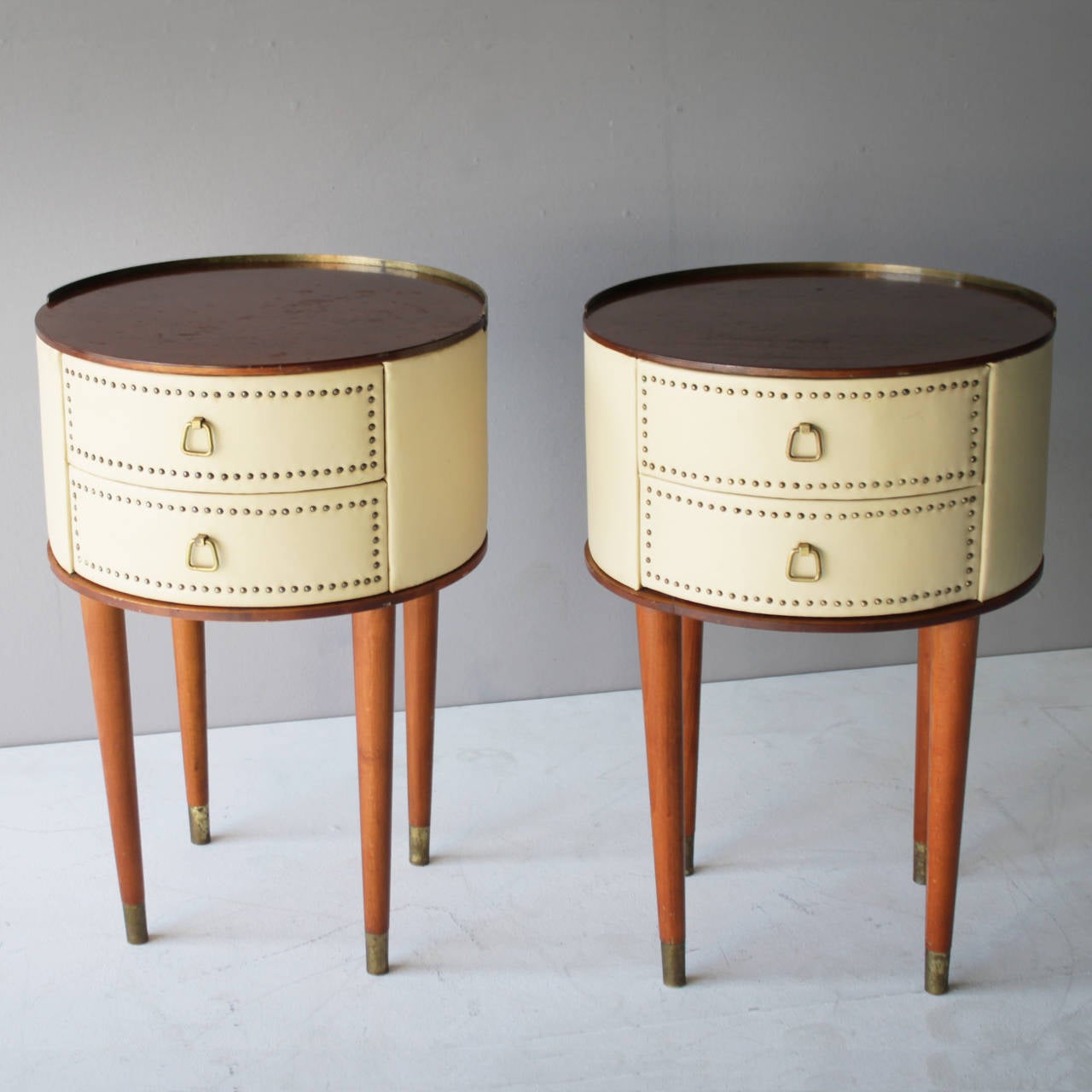 Pair of nightstands by Halvdan Petterson for Tibro, Sweden.
Walnut and cherry with off white faux leather and brass details. Each with two drawers. Labeled.