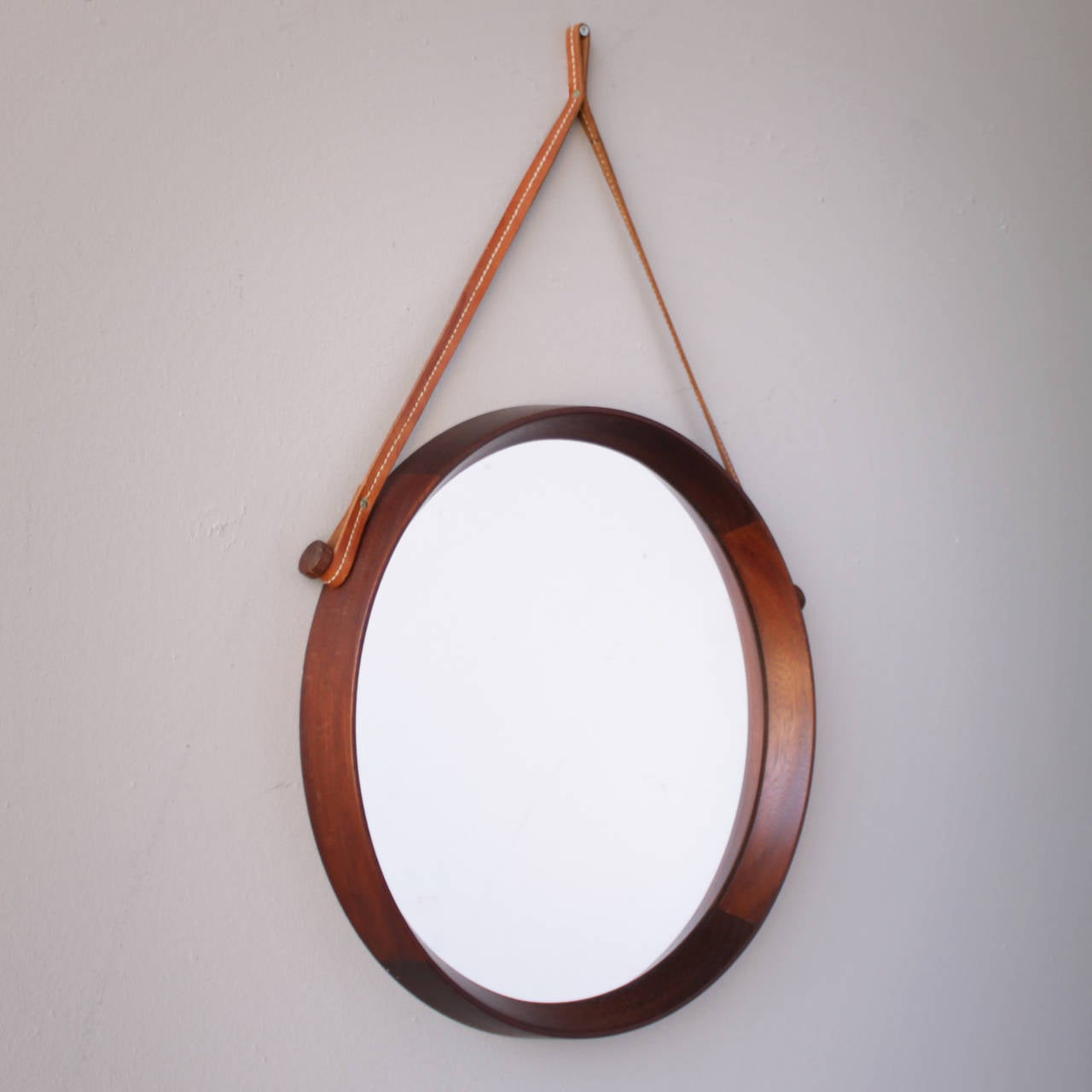 Framed mirror with leather strap by to Uno & Osten Kristiansson for Luxus, Sweden. Nice decorative mirror executed in teak. Beautiful condition.