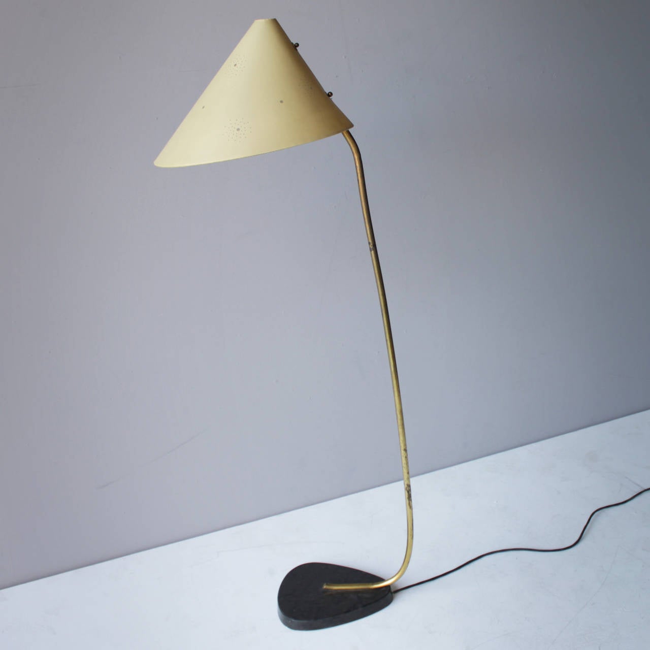 The origins of this floor lamp are unknown, but it shows strong similarities with some models of the Austrian company J.T. Kalmar. Though the marble base would rather suggest an Italian provenance. 
This very elegant lamp could be used as a reading