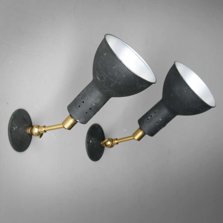 This extraordinary pair of 50’s wall lights is unmistakably Italian. The black crackled lacquer refers to the restrained industrial style of Gino Sarfatti, while the nicely detailed adjustable brass wall arms show clear similarities with Stilnovo