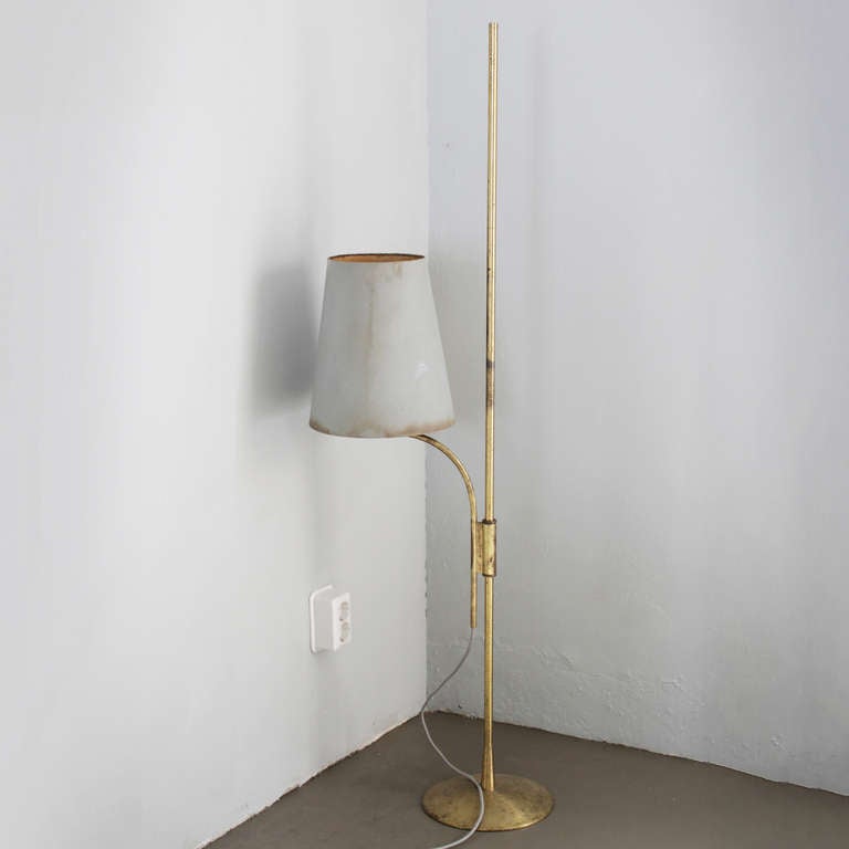 Brass adjustable Swedish floor lamp, with the original shade with wear and stains.