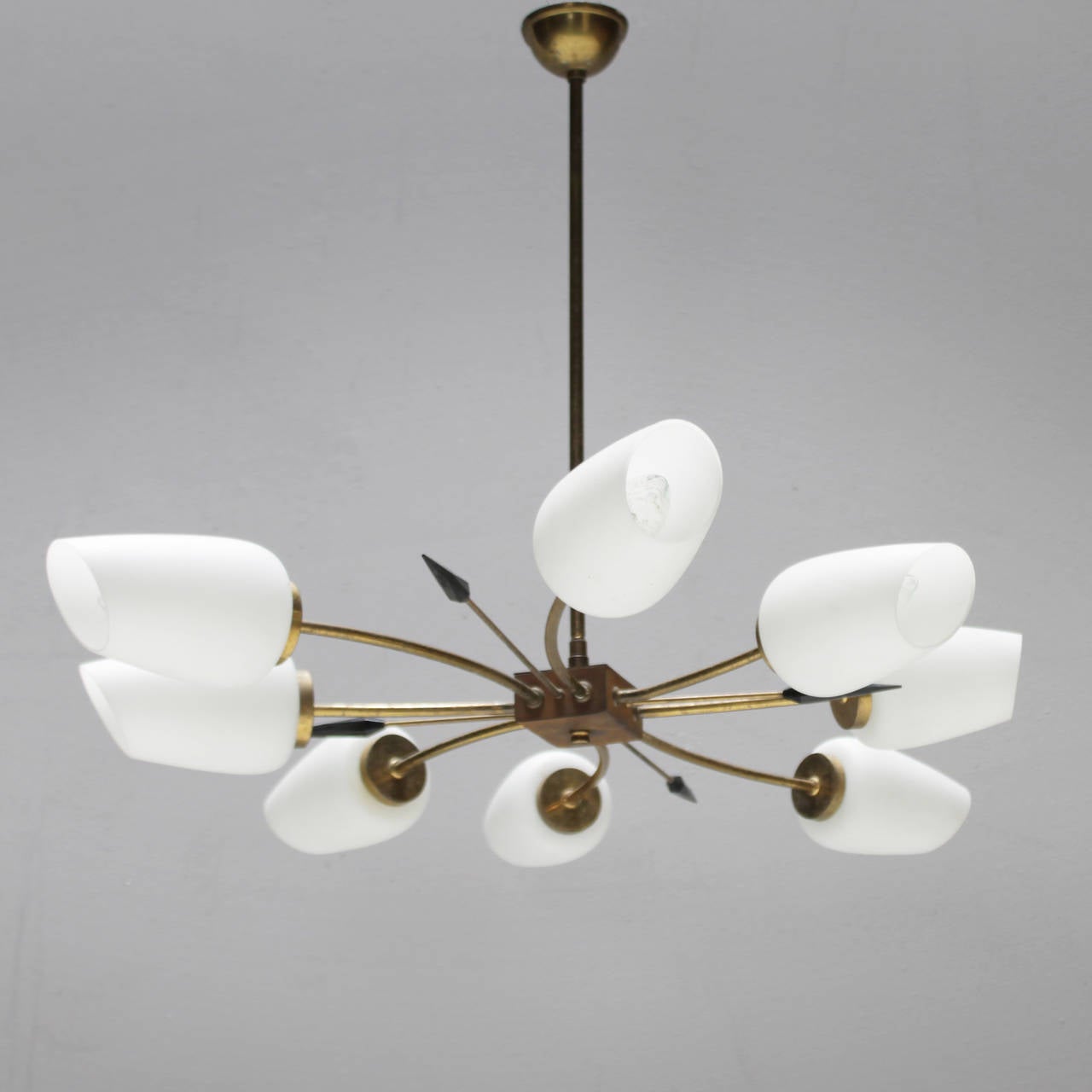 Chandelier from the fifties in the style of Stilnovo, Italy. Eight burners, each with a diffuser made ​​of white opaline glass. Some rust and and lost of gilt but overall with a beautiful patina.
Measurements: height 18.5 in. (47 cm), depth 33.8