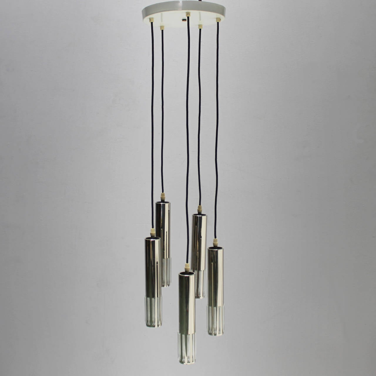 Chandelier by Schmahl & Schultz, (Wuppertal, Germany) with five pendants. Wire in good condition. Period circa 1970.
Materials and techniques: lacquered metal, glass and chrome.
Each light with one small Edison screw (SES), (E17 14-17 mm) max 60