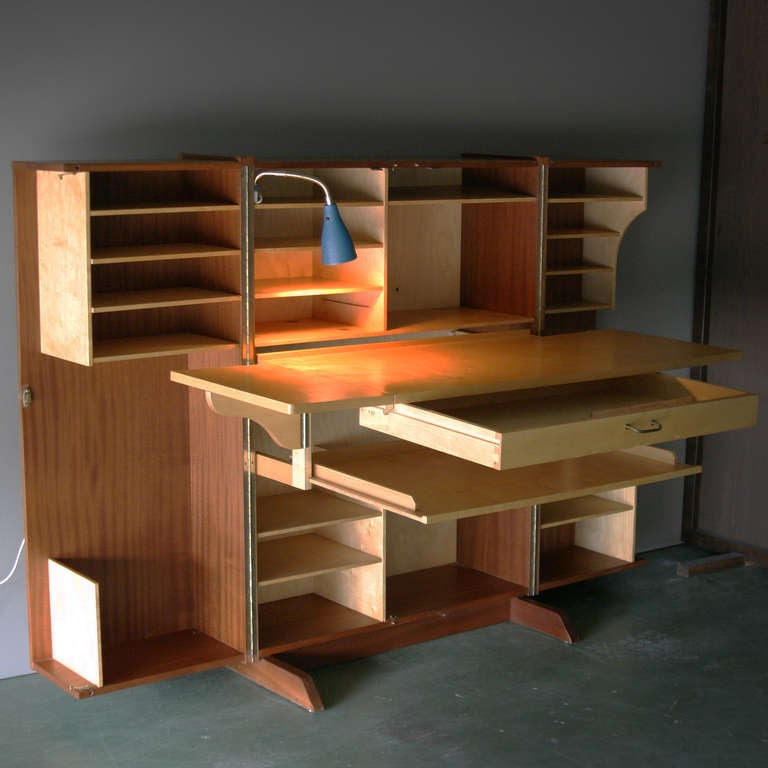 What looks like a Mid Century cabinet folds out to become a sophisticated desk, with two worktops, a drawer, lost of shelves and even a reading lamp. The contrast between the teak wood case and the light colored birch interior completes the