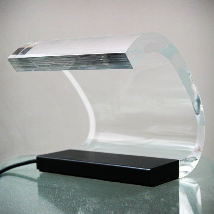 This lamp was the culmination of Colombo’s studies into the thermoplastic and optical properties of PMMA. The enamelled metal base contains the source of the light which is a neon tube. The light beam flows through the Plexiglass body and emerges