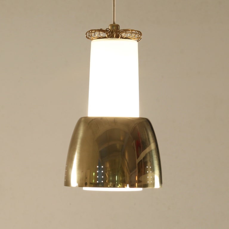 Paavo Tynell pendant lamp produced by Idman. Glass diffuser with brass shade and details. All in a perfect and original condition. The lamp has manufacturer's logo imprinted in brass part on top.