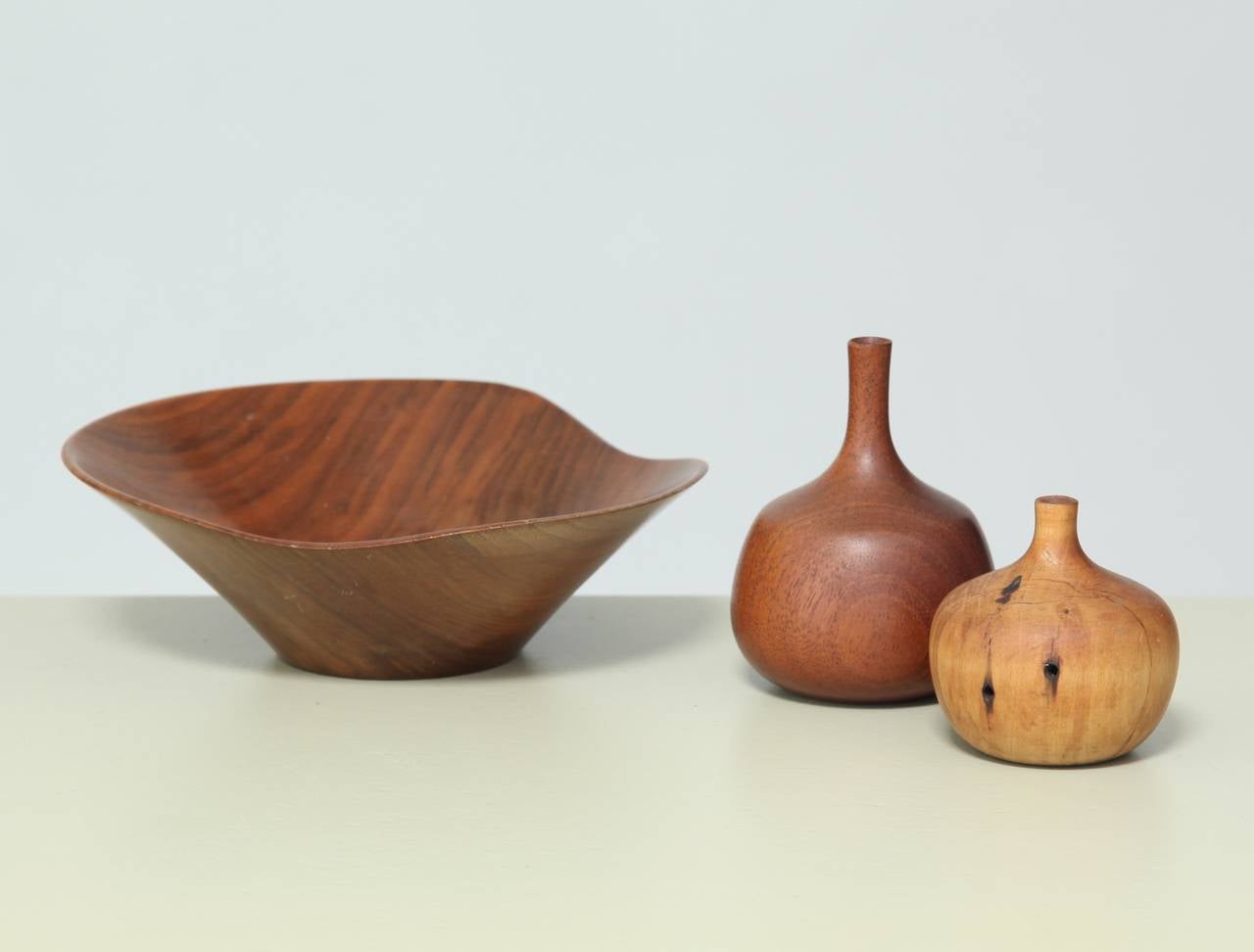 A set of three wooden objects, a bowl and two vases, by the famous American woodturner Rude Osolnik.

Dimensions are:
Bowl: height: 6.5 cm | diameter: 19 cm.
Larger vase: height: 10 cm | diameter: 8 cm.
Smaller vase: height: 7 cm | diameter: 7