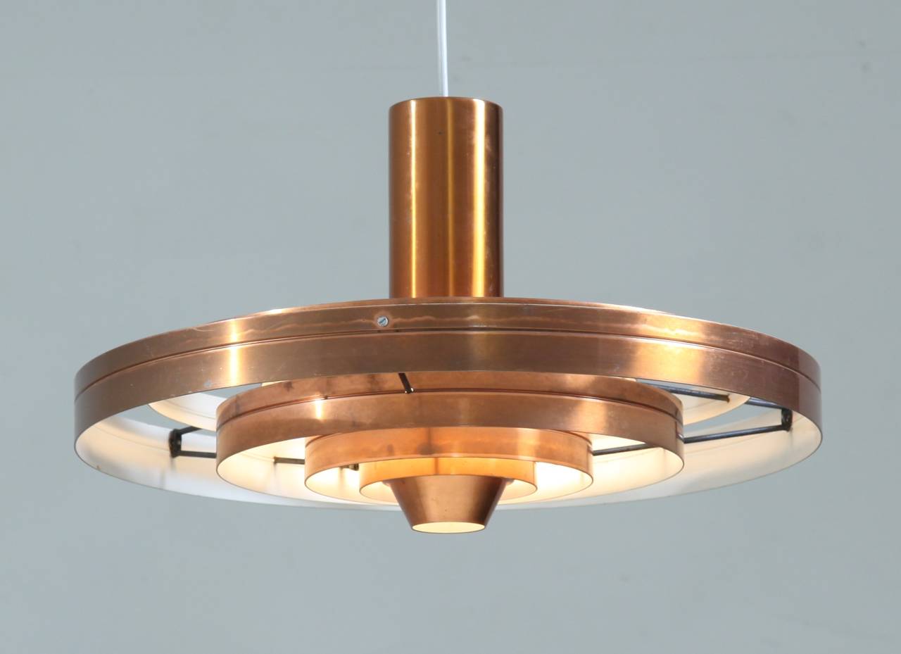 A pair of copper Fibonacci pendant lamps, designed in 1963 by Sophus Frandsen for Fog & Mørup, Denmark and awarded the Gold Medal at the Leipzig Messe in 1967. 

The chandelier gives a softly diffused light and the lamp seems to float in the air.