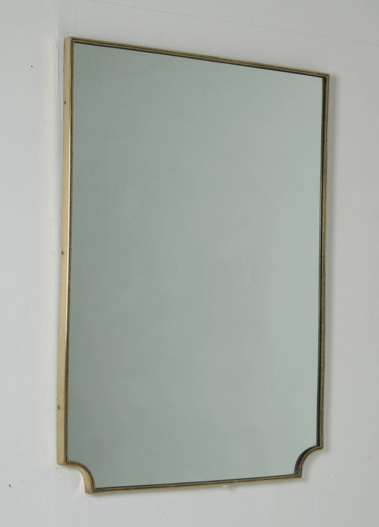 Simple and elegant 1950s brass frame mirror with a beautiful mild patina in the brass. Mirror can also be hung the other way around. 

We have several 1950s brass framed mirrors available in various models and sizes. Please contact us for more