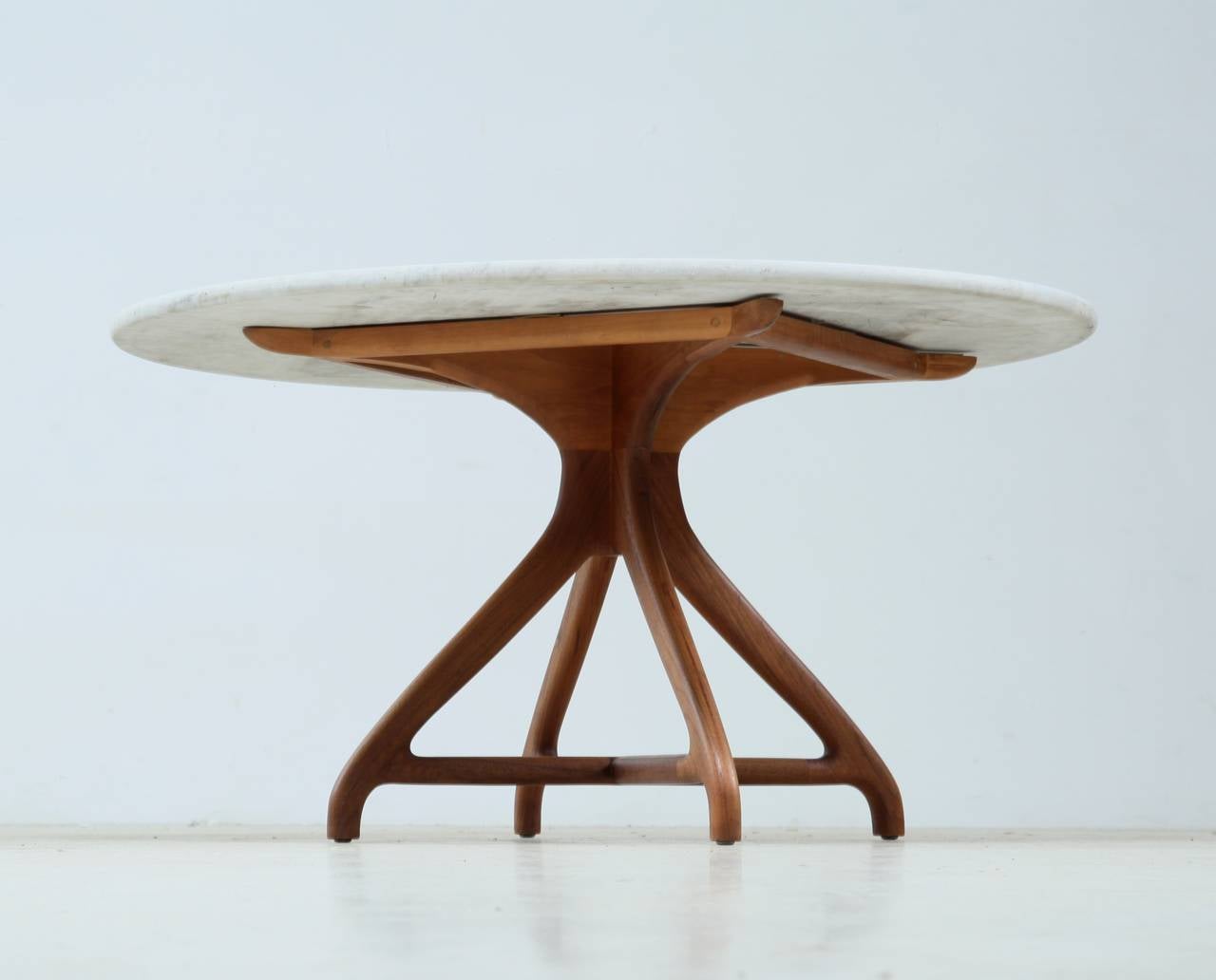 A custom handmade Richard Harrison table made of a sculptural walnut base with a round marble top.

Matching chairs also available.