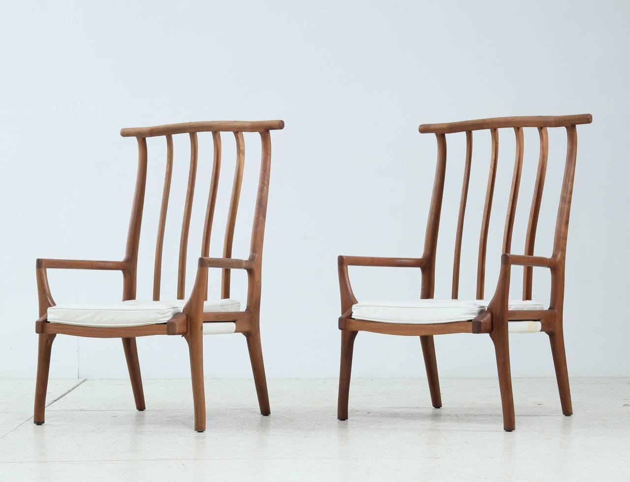 A pair of two custom, handmade Richard Harrison armchairs. These remarkable, lightweight and sculptural chairs are made of walnut with a white leather seat pad. The chairs have beautiful connections and are in a perfect condition.

We have two