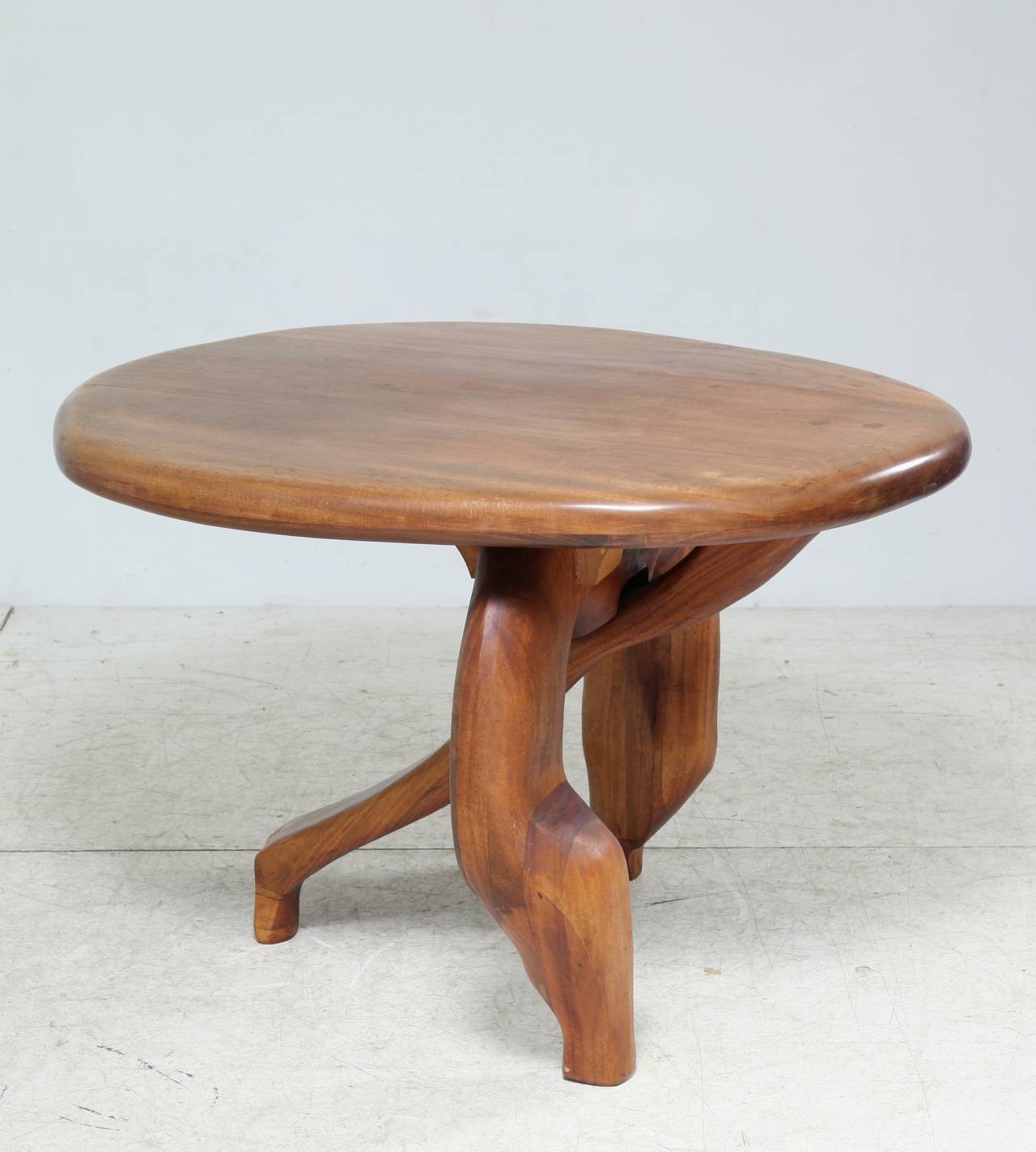 Solid wood three legged floating table.
This unique object is suitable as small dining or gueridon table. 
We have not yet traced the maker, but it has the organic shapes and fullness in the tradition of Sam Maloof and Wharton Esherick.