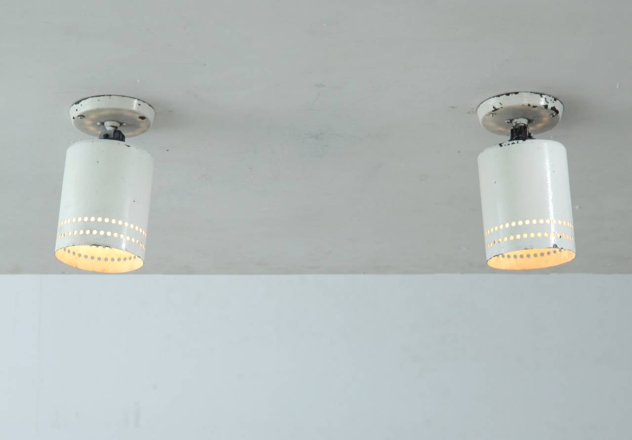 Two Industrial style French adjustable spots in the manner of Disderot with a ceiling mount, made of white metal with perforations.
Very suitable to use in a kitchen or storage setting or to light special objects.
The lamps have a heavy patina,