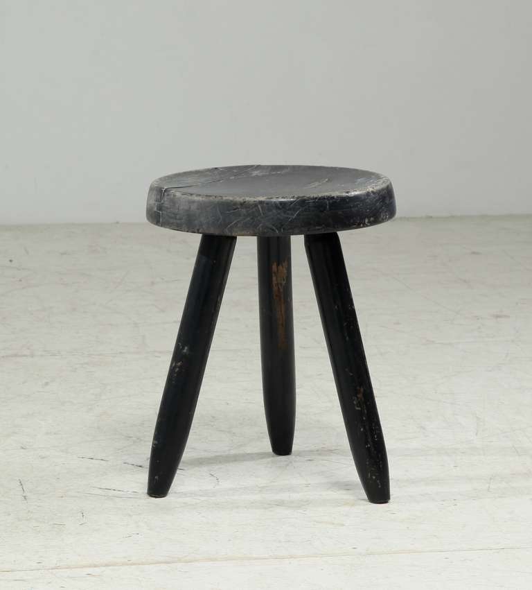 A medium high black stool from the 1960s, designed by Charlotte Perriand. 
The first tripod stool of this type by Perriand was designed in 1947 and produced by Georges Blanchon’s Bureau Central de Construction. In 1956 Perriand designed this black