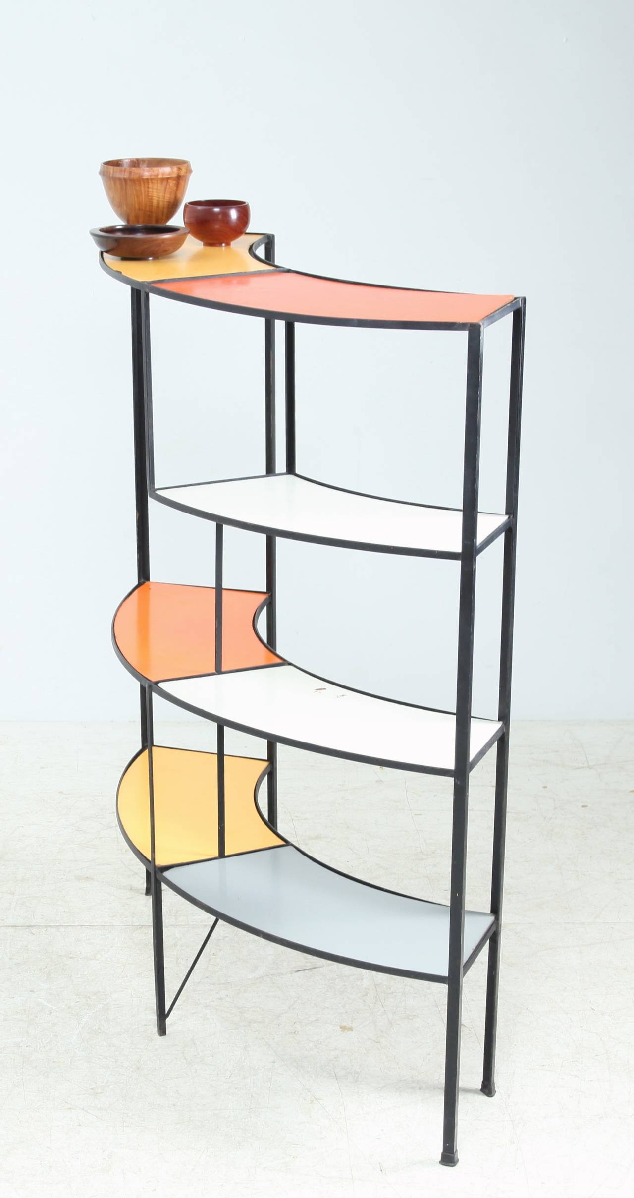 A colorful shelving unit by American designer Frederic Weinberg.
This unit is made of a wrought iron frame with coated removable wooden shelves.

The damage on the white shelve can be restored upon request.