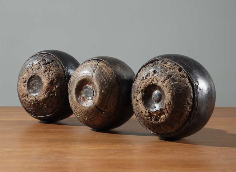 A set of three vintage Pétanque balls from France, made of wood and metal.
The wooden band that is is 'wrapped' around the oak ball itself, has a wonderful patina from the intensive usage, it almost feels like leather. 
Very decorative and also
