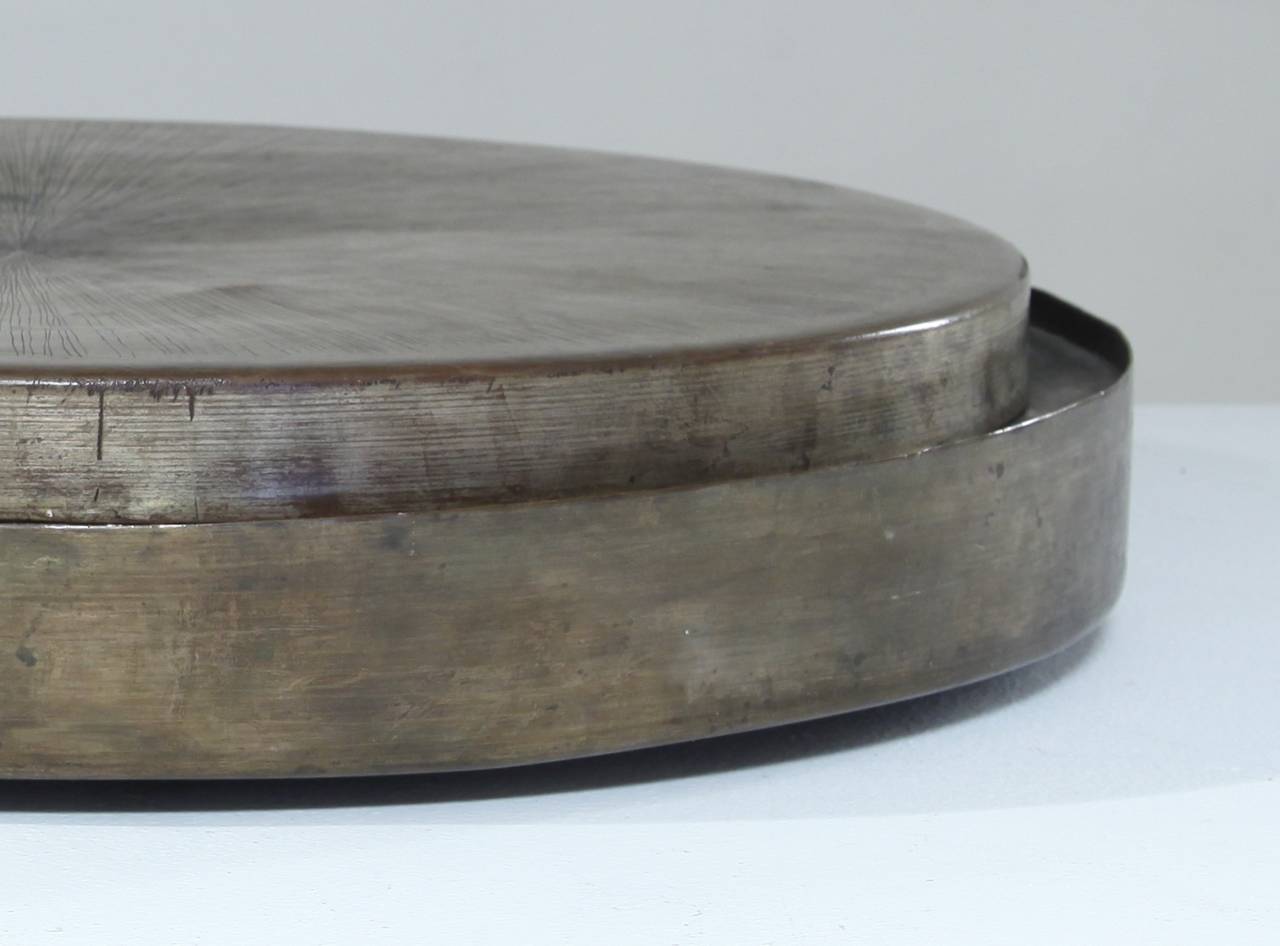 A very rare, round patinated copper bowl or container with lid by Lorenzo Burchiellaro. The bowl is made of patinated copper and the lid is incised with a beautiful and subtle pattern of lines.
This piece is in a great condition and signed by