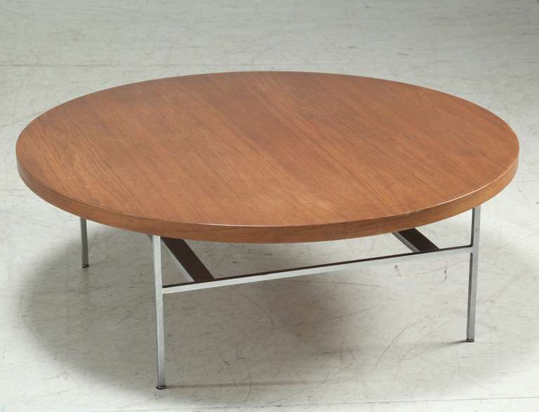 A large and heavy round coffee table by George Nelson from the 1950s, for the Herman Miller company. The walnut top rests on an aluminum base.