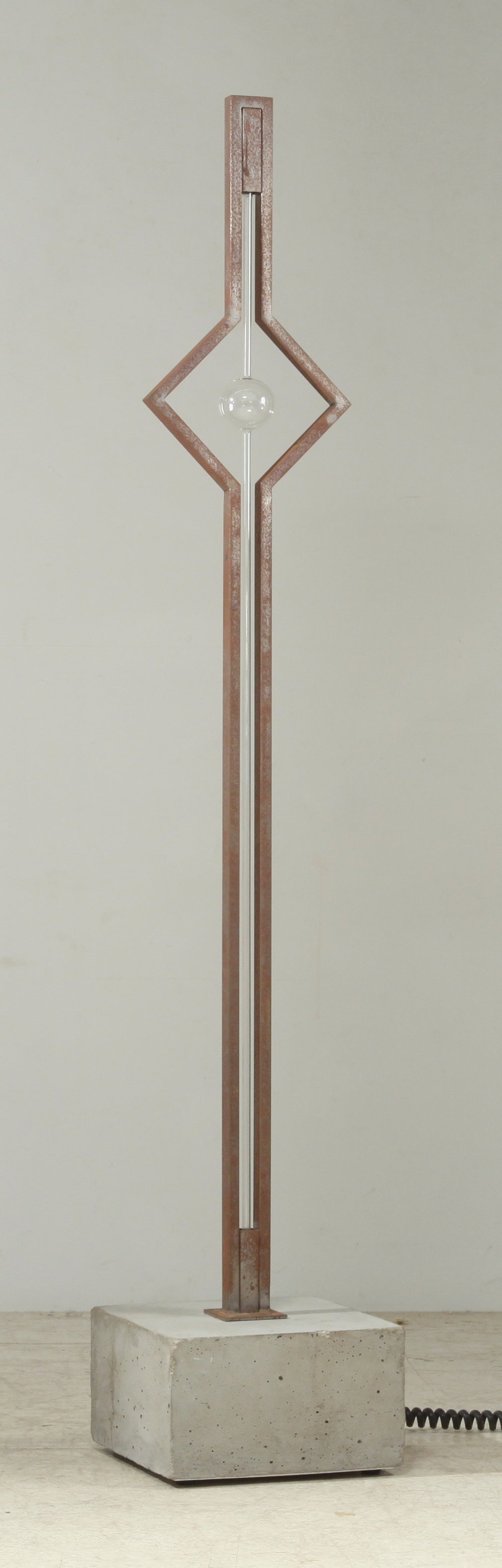 A very rare and published floor lamp designed in 1987 by Pentagon member Gerd Arens. The lamp is made of a concrete base and a steel frame with a neon light on it. Towards the top the frame and the neon tubes form a square with a globe inside.
