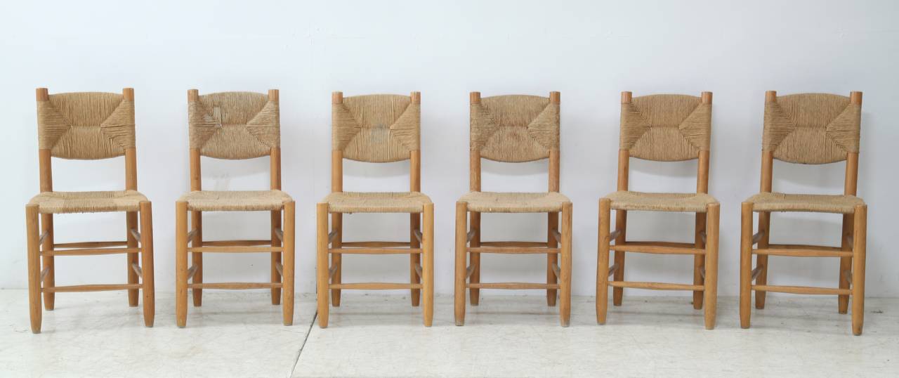A set of six Bauche chairs by Charlotte Perriand, produced by Steph Simon, for the Les Arcs ski-resort, 1960s. The chairs are made of ash with original rush seating and backrest.