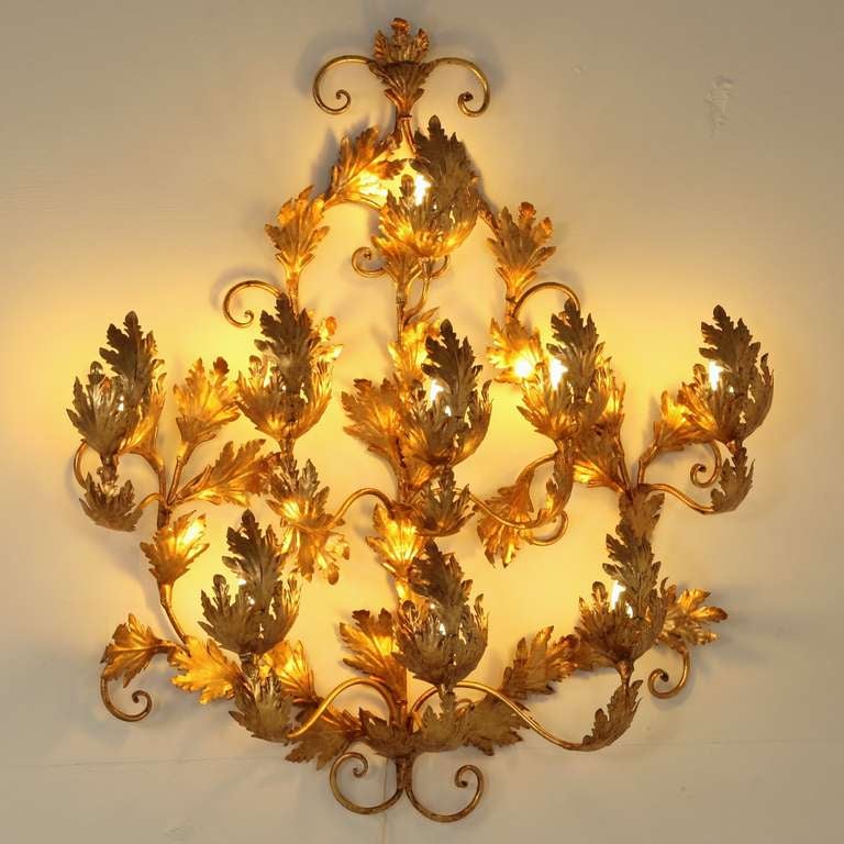 Large illuminating wall applique in gold leaf.
The wall applique holds nine light bulbs and is in itself already a very decorative piece, when lit is fascinating.

Perfect condition, wiring checked by our in-house professional and ready for