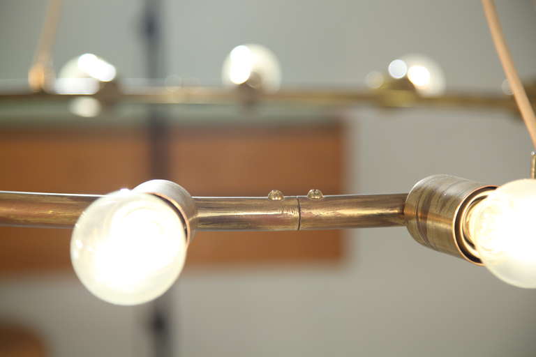 A large and minimalistic brass circular chandelier 1