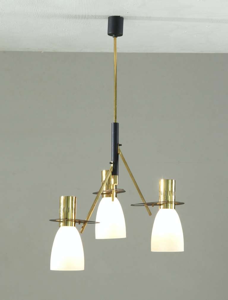A three-armed Italian brass pendant in the manner of Stilnovo, with milk glass shades. The lamp is currently wired to shine upwards, but it can be rewired to position the shades downwards.

Matching sconces also available