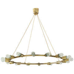 A large and minimalistic brass circular chandelier