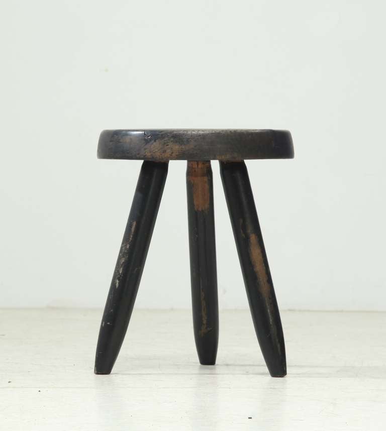 A medium high black stool from the 1960s, designed by Charlotte Perriand. The first tripod stool of this type by Perriand was designed in 1947 and produced by Georges Blanchon's Bureau Central de Construction. In 1956 Perriand designed this black