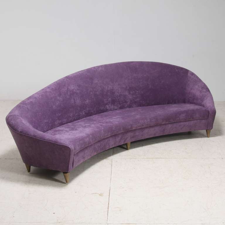 A large and curved sofa reminiscent of the work of Ico Parisi. It floats on six small legs. Newly upholstered in a wonderful rich violet fabric and in a mint condition.