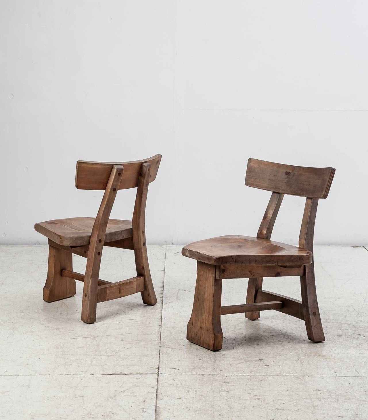 A pair of studio crafted chairs of knotty pine by Habitant Shops. The chairs are marked by Habitant Shops and are in a great vintage condition.