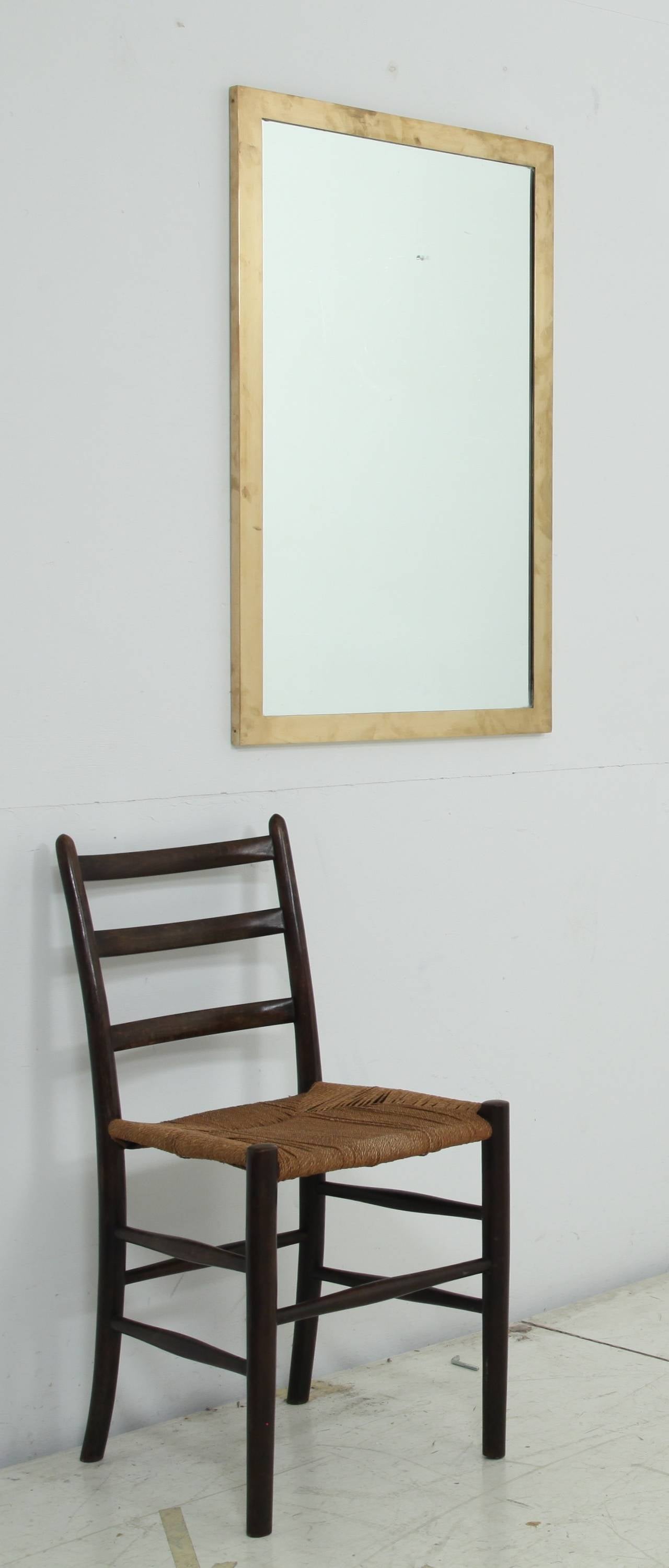 A rectangular wall mirror with a heavy brass frame on a wooden base.
Simple and elegant
