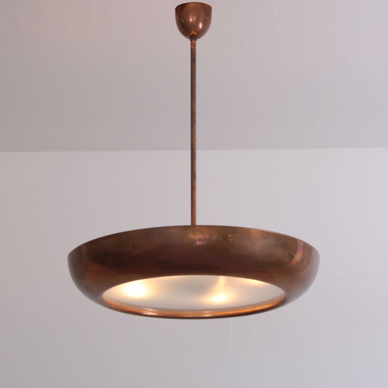 Rare, huge ceiling lamp from the 1940s. A satined glass plate is surrounded by a round brass or copper corpus. The lamp gives a very nice light and atmosphere.