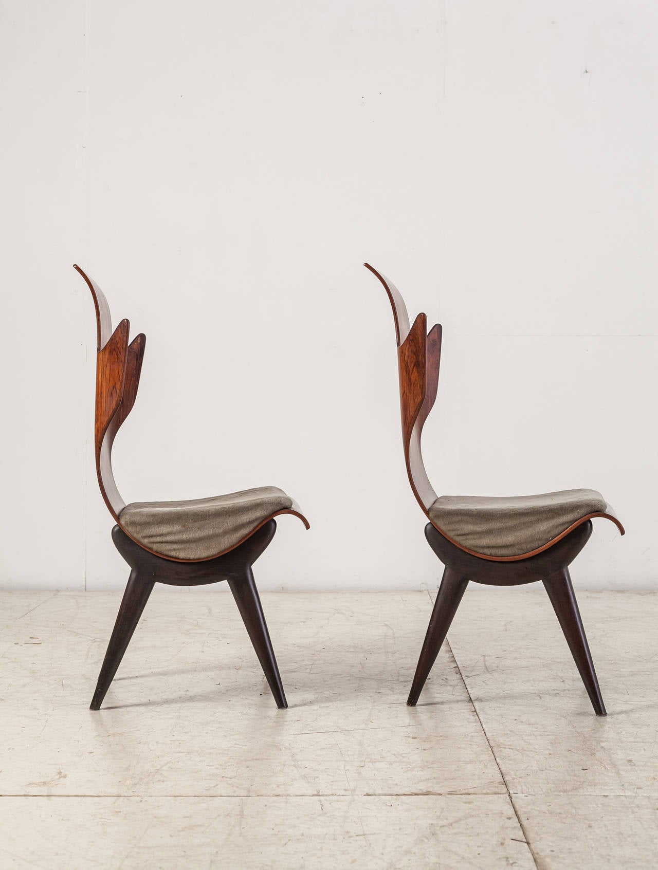 A pair of rare, sculptural Pozzi & Verga model ‘2/R’ or 'Flame' chairs, designed by Dante Latorre. The chairs are made of bent, laminated rosewood on an ebonized ash frame. They have fixed cushions with a grey velour upholstery.
The rosewood has a
