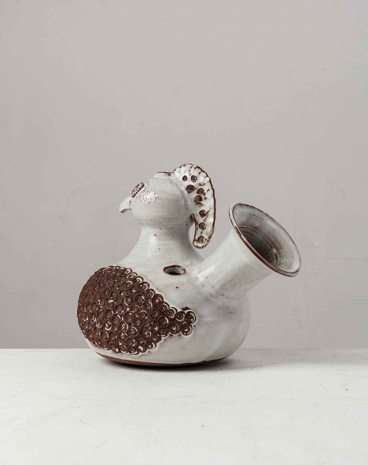 A white and brown ceramic vase in the shape of a hen. This piece is signed by Pouchain and is in a perfect condition.

Pouchain is a French sculptor and ceramist and the son of Jacques Pouchain.