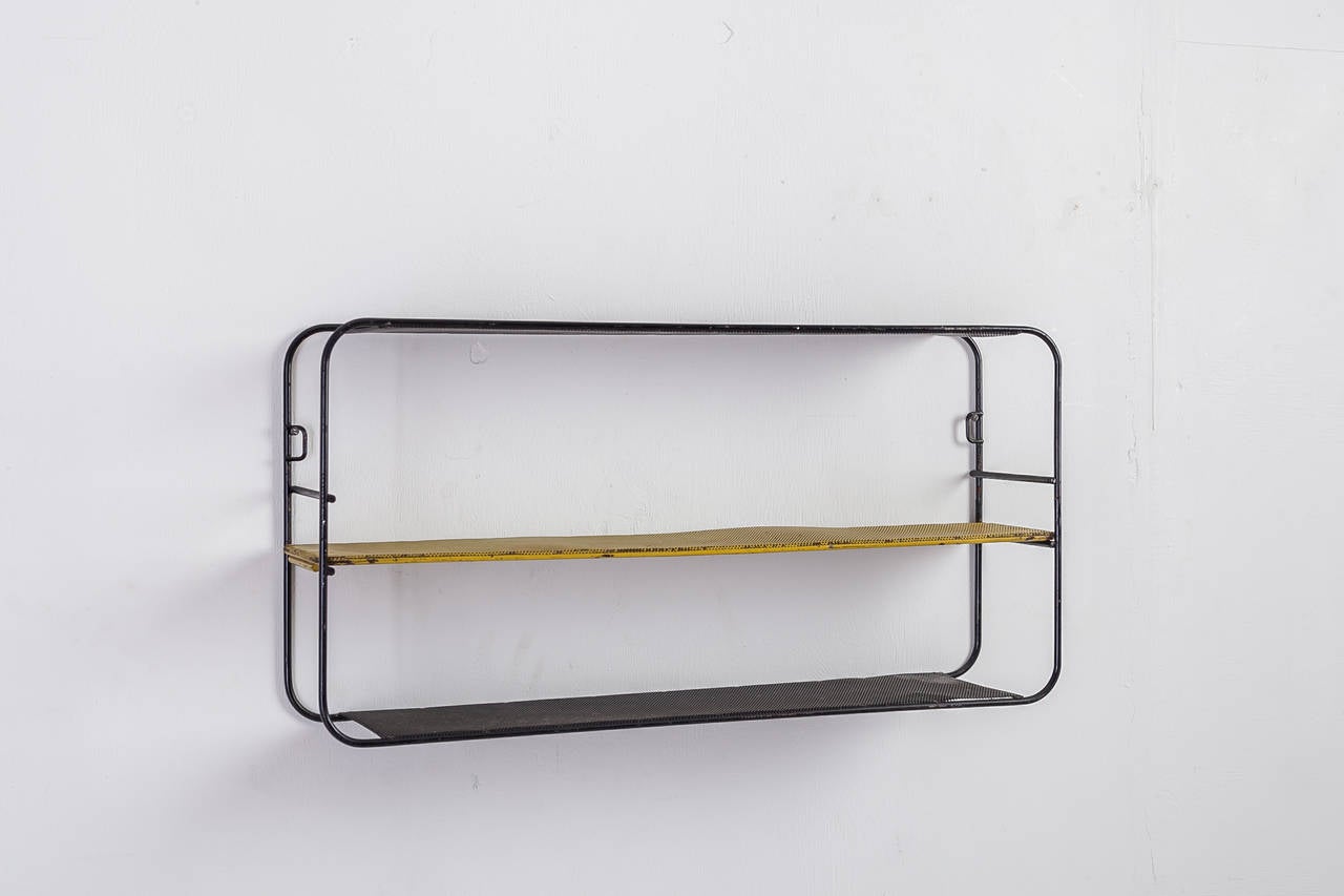 A 1950s Mathieu Matégot wall shelving unit in black and yellow metal. The metal has the typical perforations that Matégot's work is known for.
There are some minor damages to the lacquer, but this piece is in an overall good and original condition