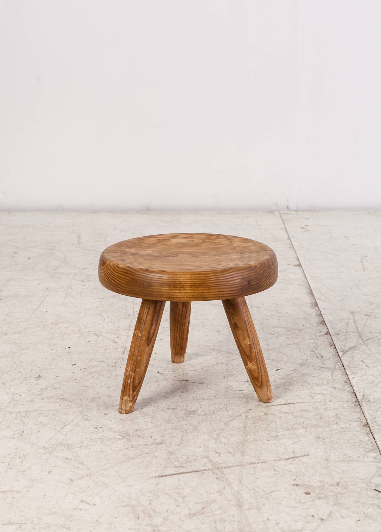 A beautiful low stool by Charlotte Perriand in ash. It has a thick and slightly concave seat.
The stool has the typical Perriand connections and has a beautiful wear and dark patina.