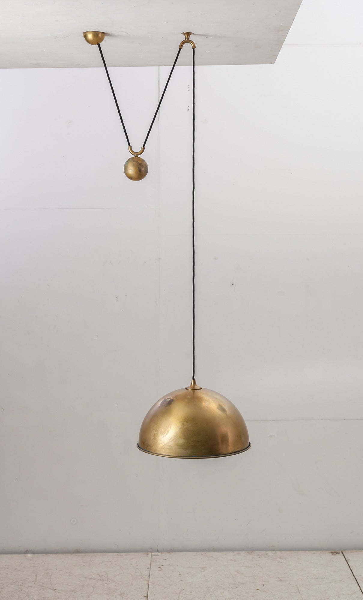 A beautiful 'Posa' pendant lamp in brass by German designer Florian Schulz. The lamp is adjustable by means of the globe shaped counterweight in the middle.
The lamp is in a very good state with a beautiful and strong patina.