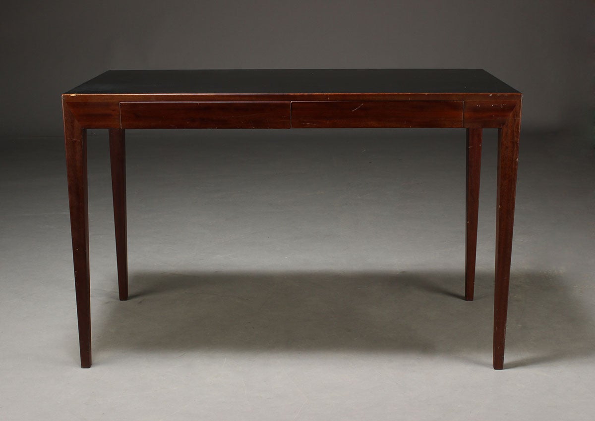 A small and rare Severin Hansen desk on elegant tapering legs for Haslev Møbelsnedkeri, Denmark. The dark mahogany desk has a black lacquered wooden top and two drawers.
The diagonal lines of the connection between the legs and the side of the