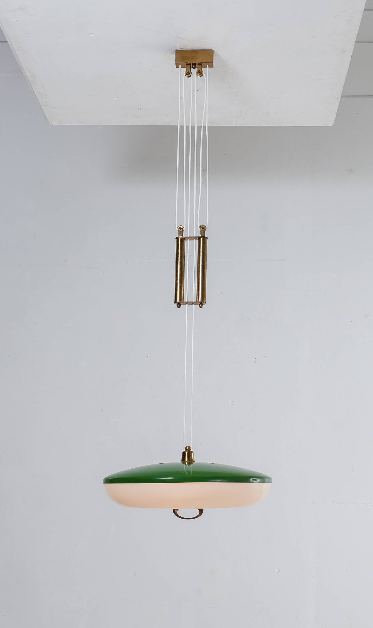 A 1950s Stilnovo pill shaped pendant made of a green lacquered metal shade with a plastic diffuser. The lamp is height-adjustable by means of the brass pull and the beautiful double counterweight in brass.

* This piece is offered to you by