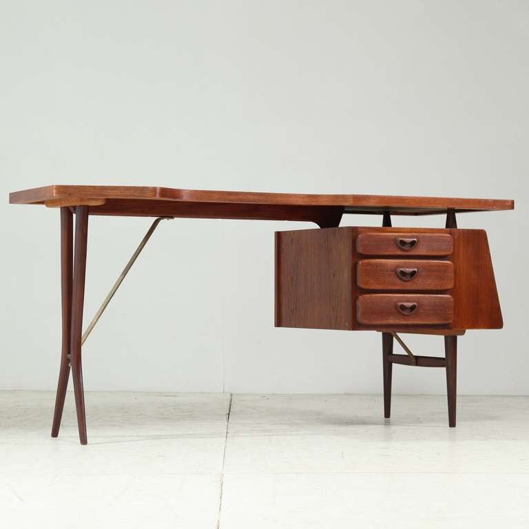 Teak desk on elegant, thin legs with three drawers, by Dutch cabinet maker Louis Van Teeffelen for Wébé

The desk has a Scandinavian quality,  with Italian aesthetics.
Perfect condition.